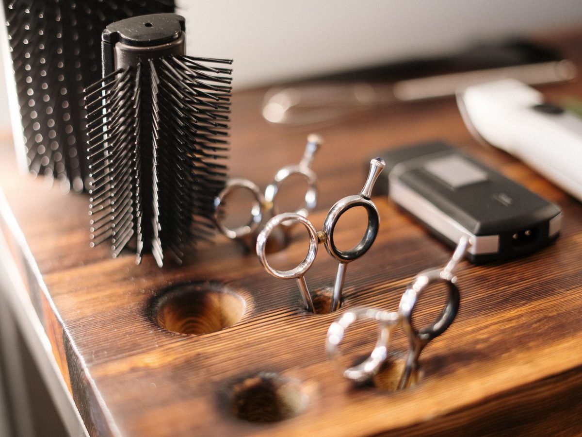 Herramientas e insumos profesionales de barbería ordenados sobre un mesón de madera